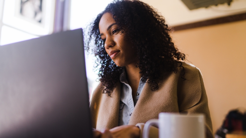 Woman using laptop computer while moving to Business nbn