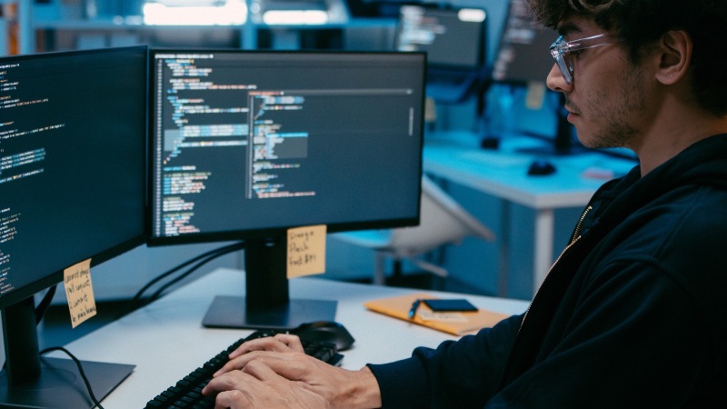 Programmer working on dual monitors for dark we audits for Halls Gap Businesses